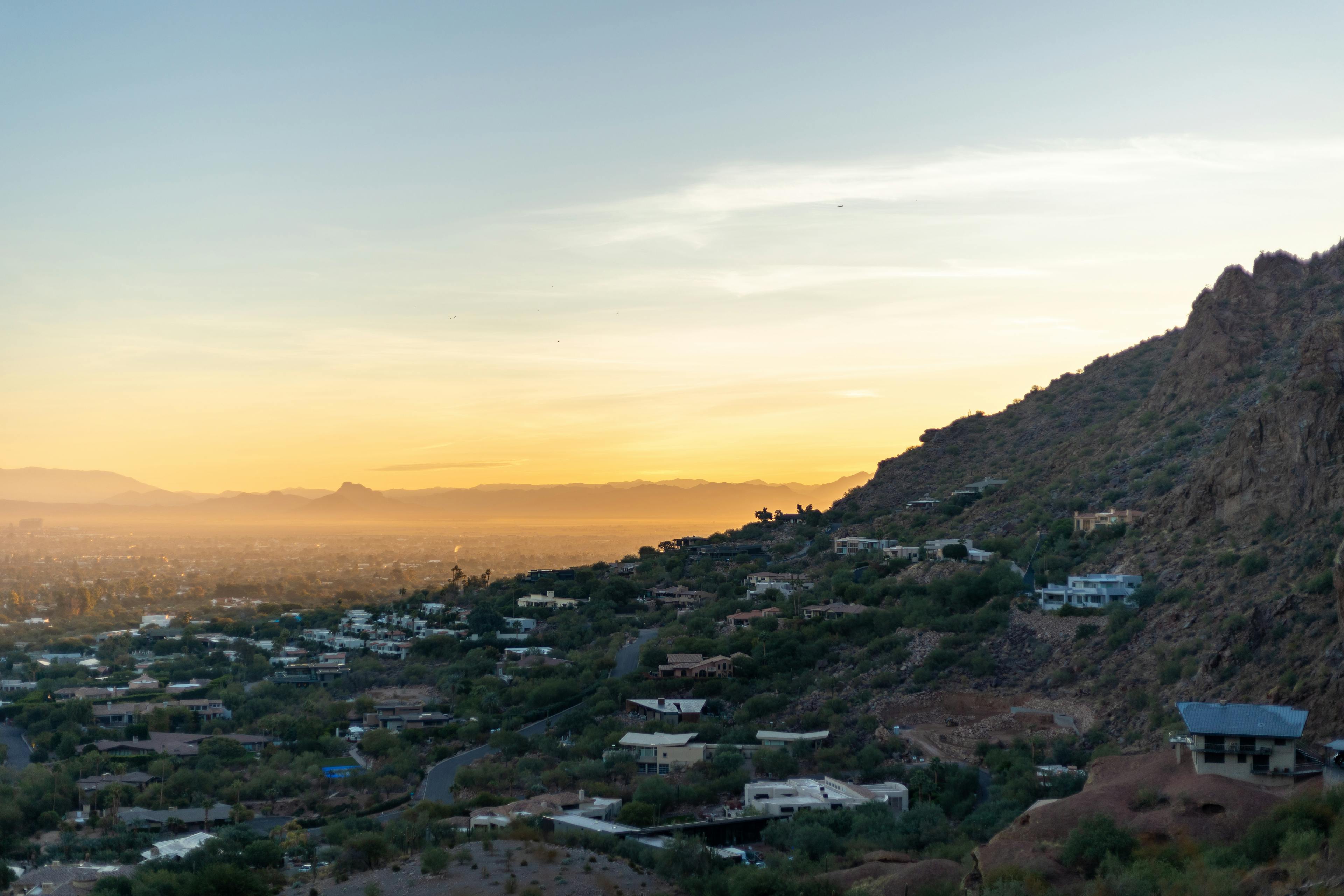 Phoenix Valley hillside homes at golden hour, mountains in the distance